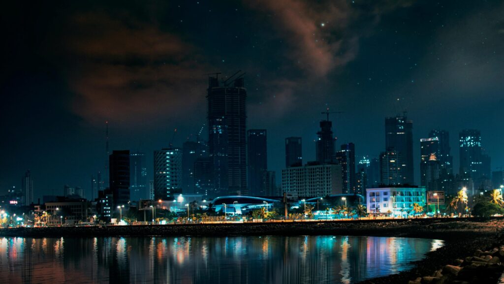 Stunning view of Mumbai's skyline at night, reflecting on water.